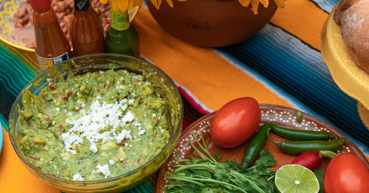 Colorful Mexican feast with fresh guacamole, sunflowers, and vibrant ingredients on a table.